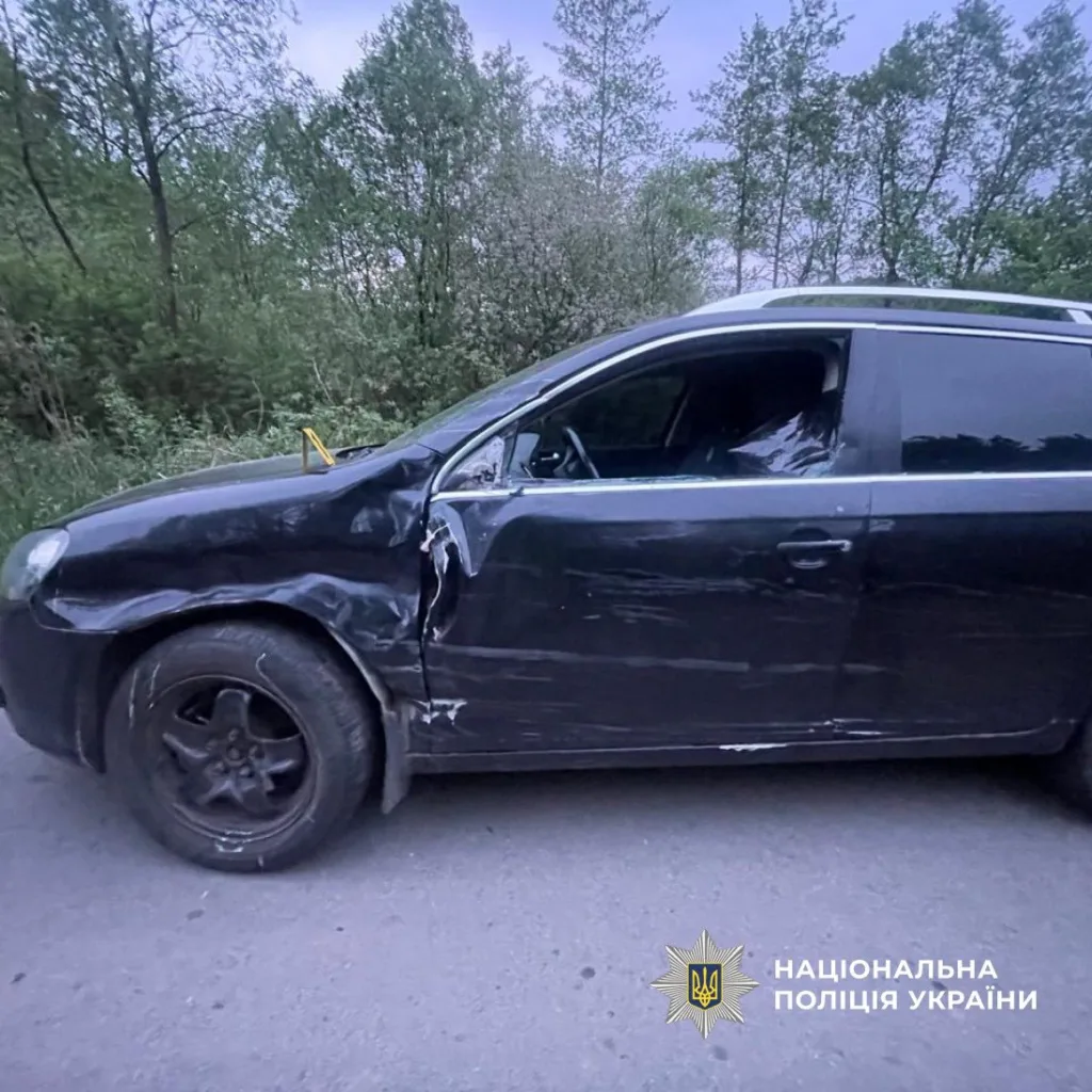 Пошкоджений чорний автомобіль після ДТП на дорозі