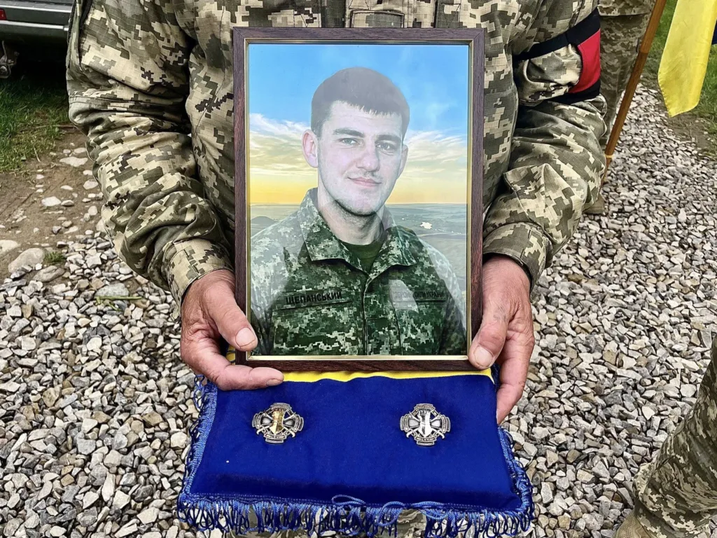 Військовий тримає фото загиблого героя України