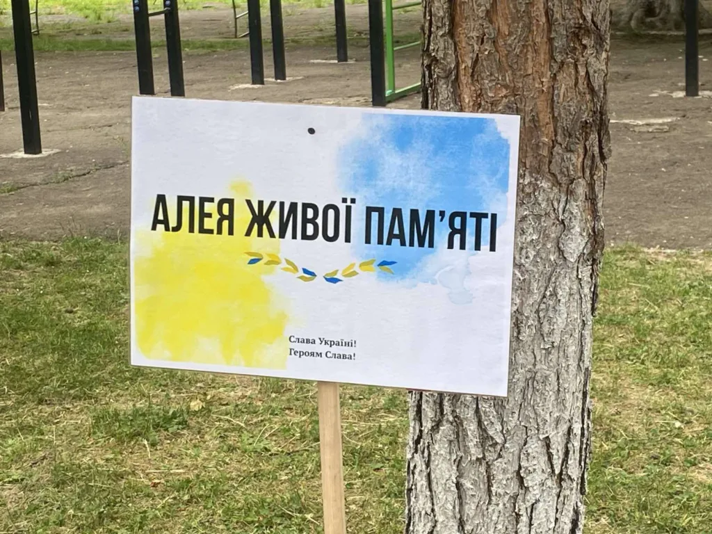 Табличка з написом Алея живої пам’яті на дереві