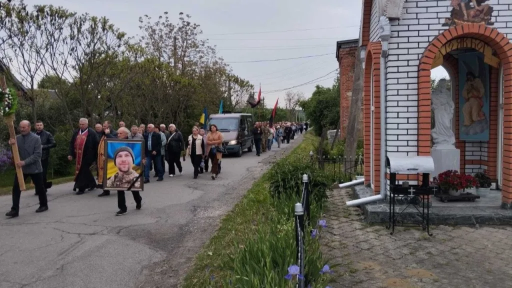 Прощальна хода селом із прапорами та священником