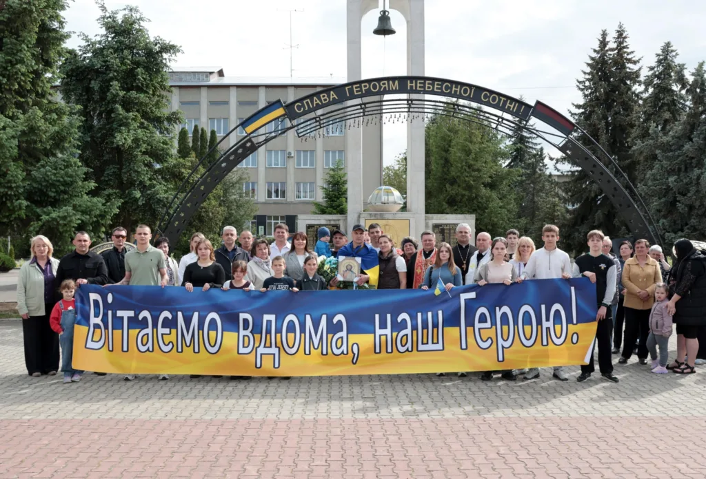 Люди вітають героя перед пам’ятником у місті