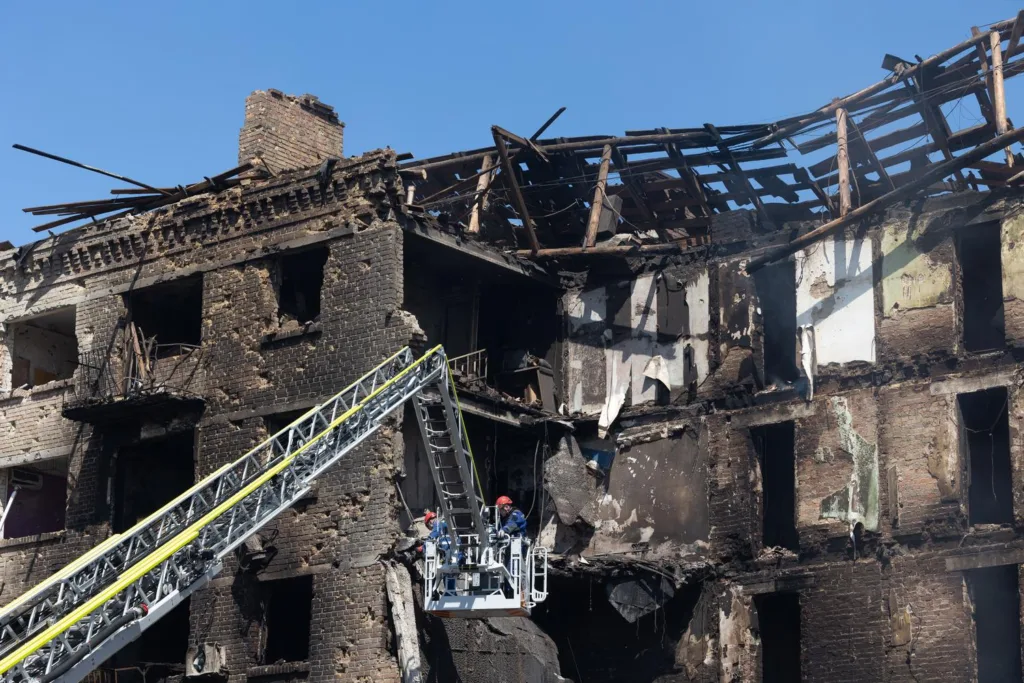 Пожежники оглядають зруйновану після пожежі будівлю