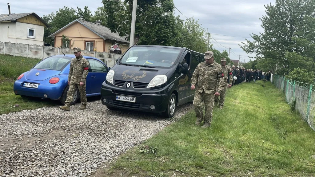 Військові супроводжують похоронну процесію селом