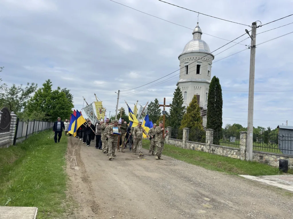Військовий похід з прапорами біля церкви