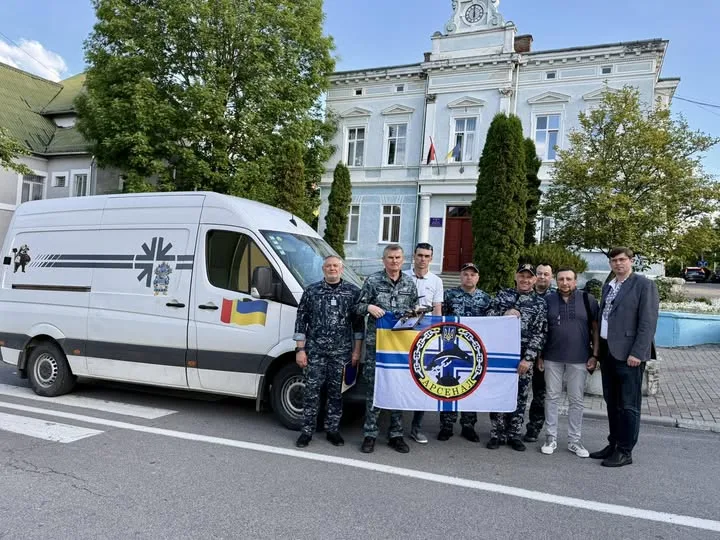 Військові з прапором біля мікроавтобуса в місті