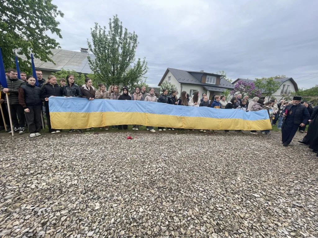 Люди тримають великий прапор України на вулиці