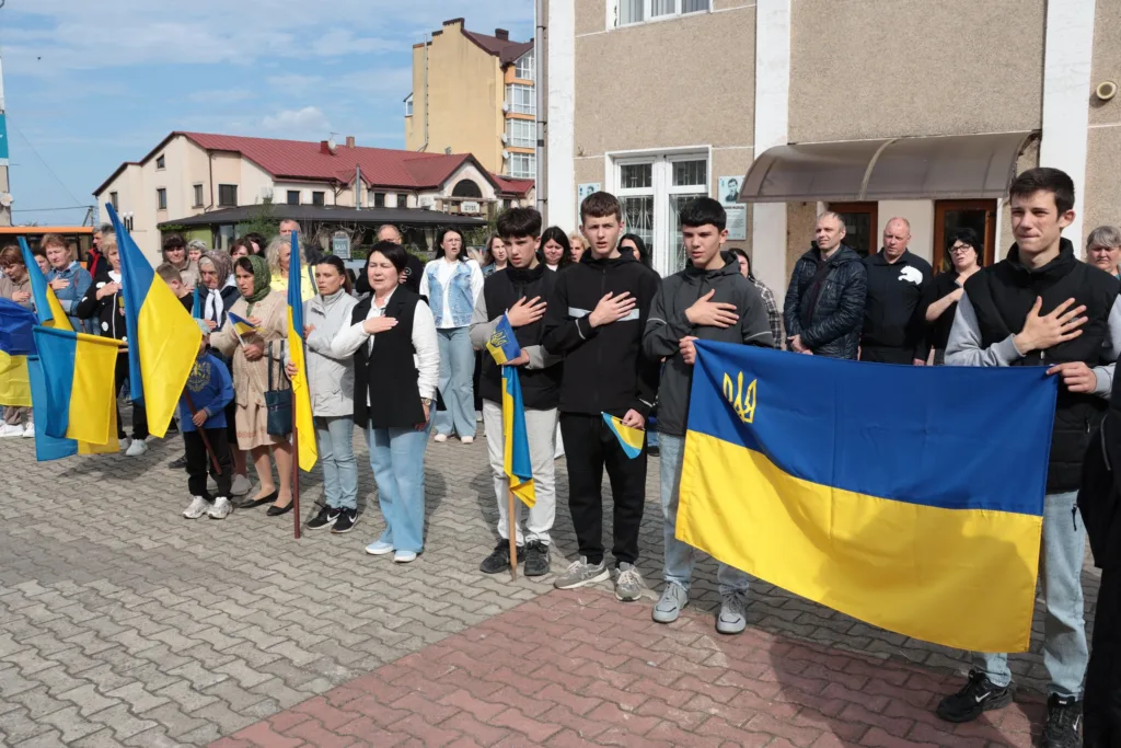 Люди з українськими прапорами на патріотичному заході