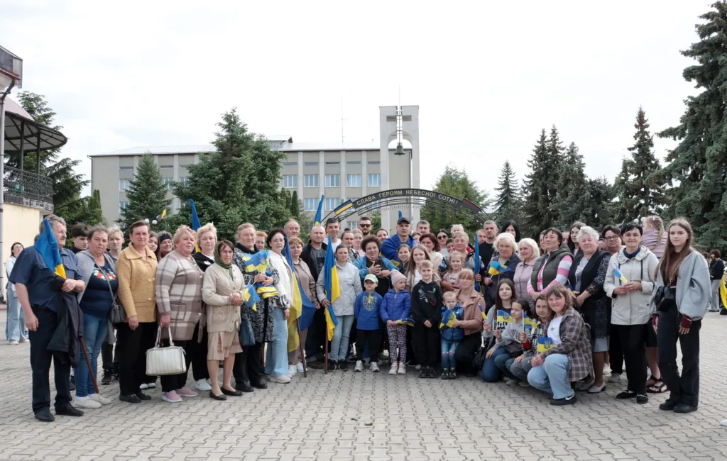 Група людей з українськими прапорами на площі