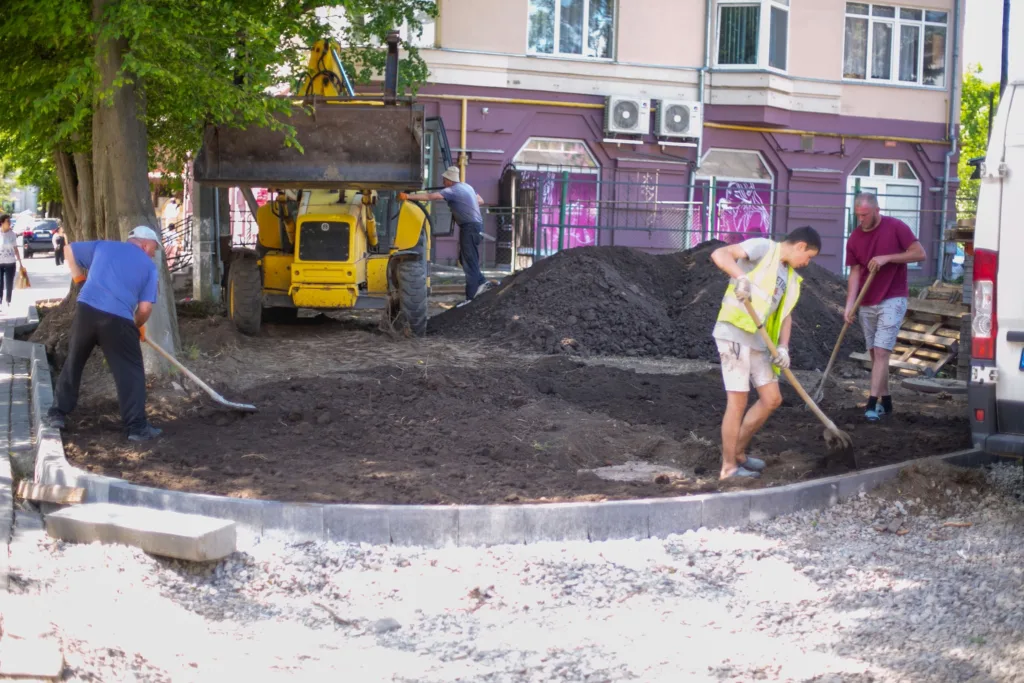 Робітники ремонтують тротуар і працюють з ґрунтом