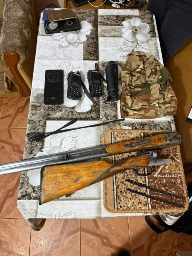 Зброя, рації та військове спорядження на столі