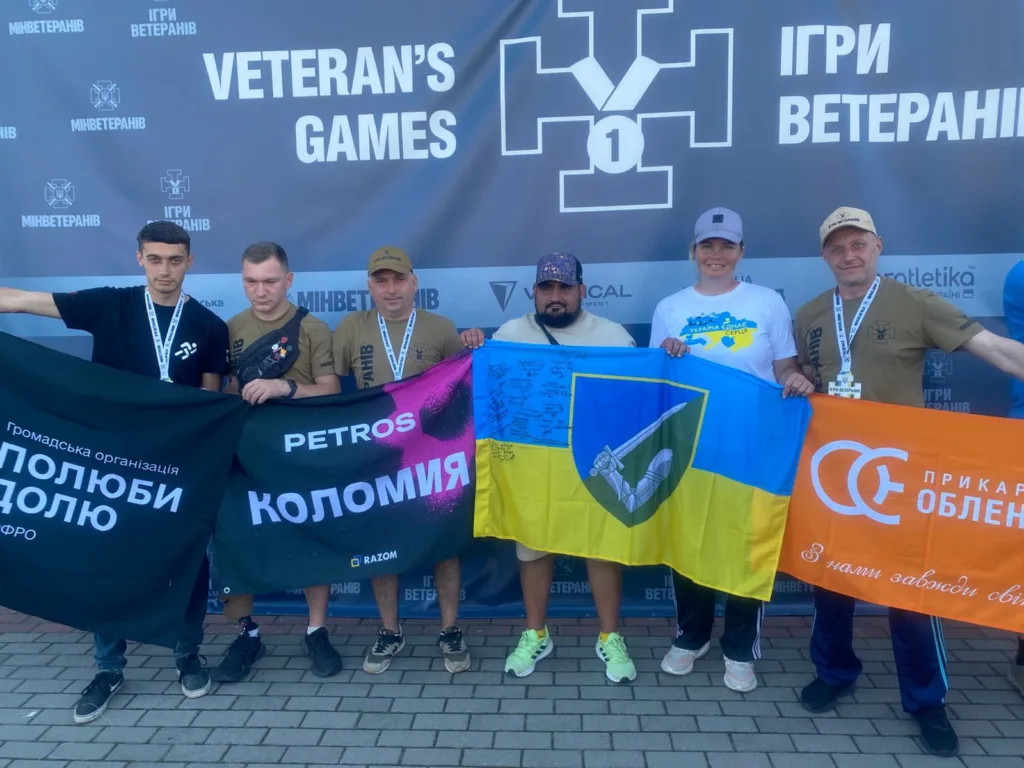 Учасники Ігор Ветеранів тримають прапори України