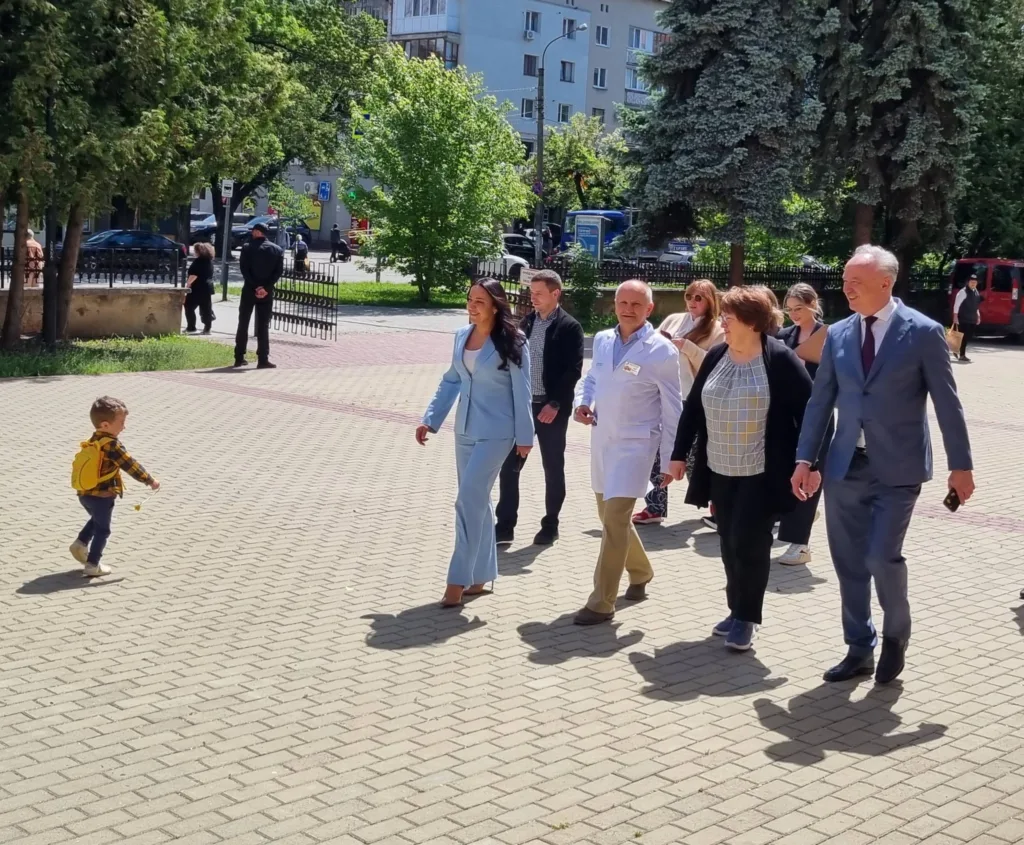 Група людей прогулюється подвір’ям у сонячний день