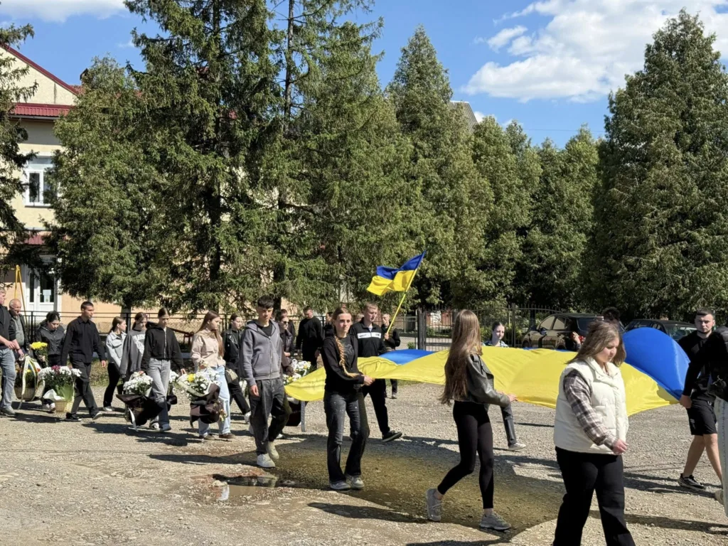 Люди несуть великий прапор України на вулиці
