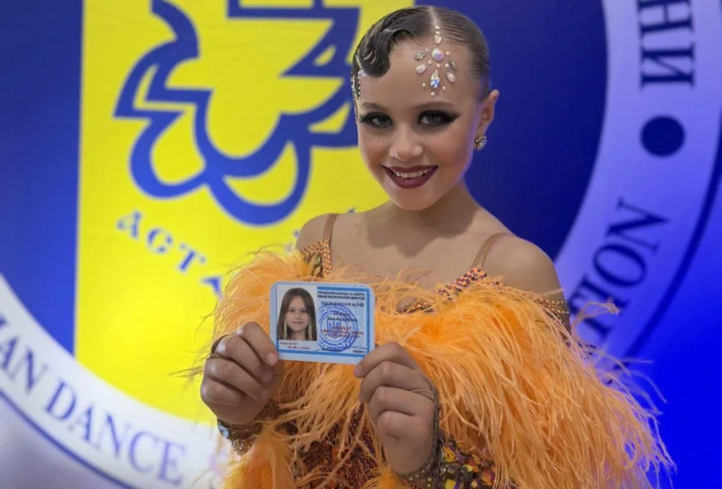 Юна танцівниця з посвідченням на змаганнях