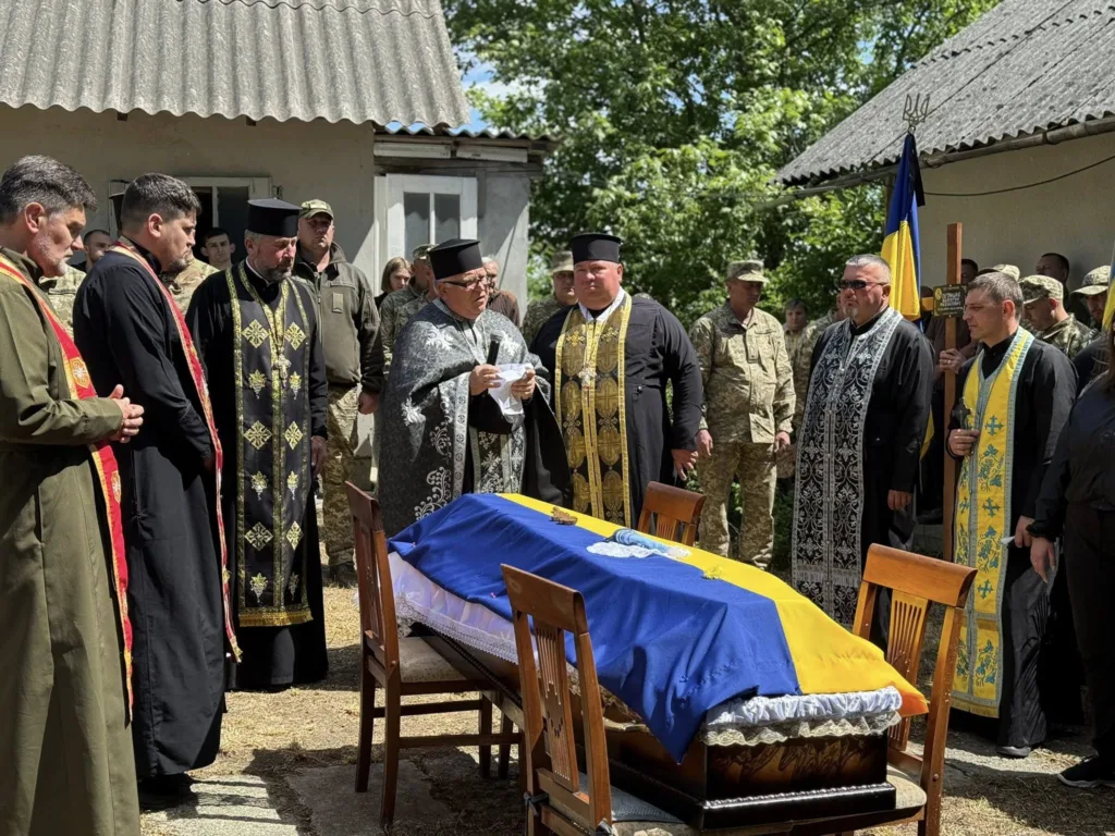 Похорон воїна з труною, покритою прапором України