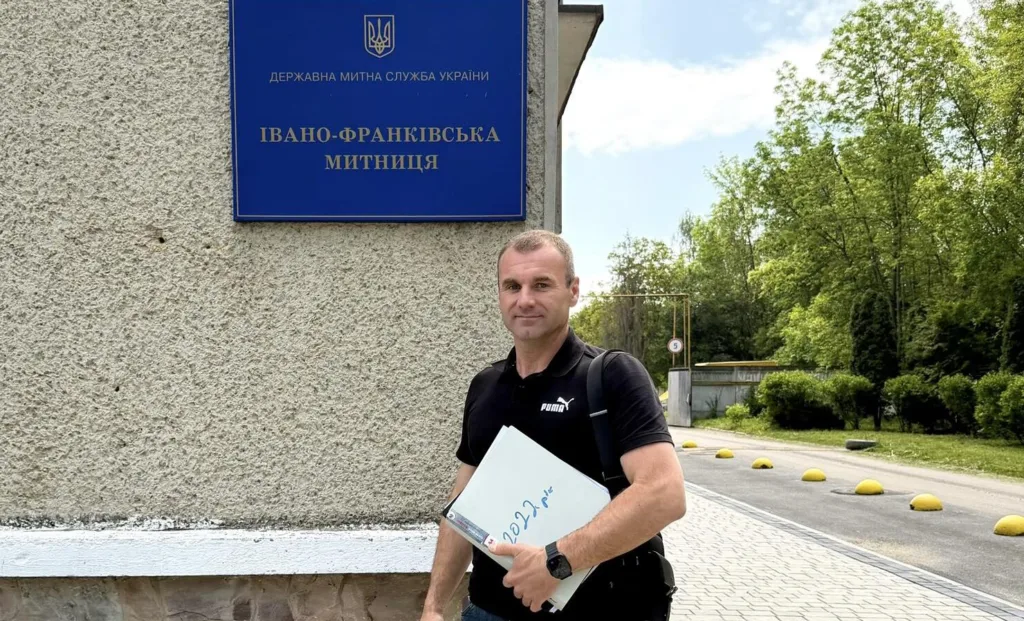 Чоловік біля вивіски Івано-Франківської митниці