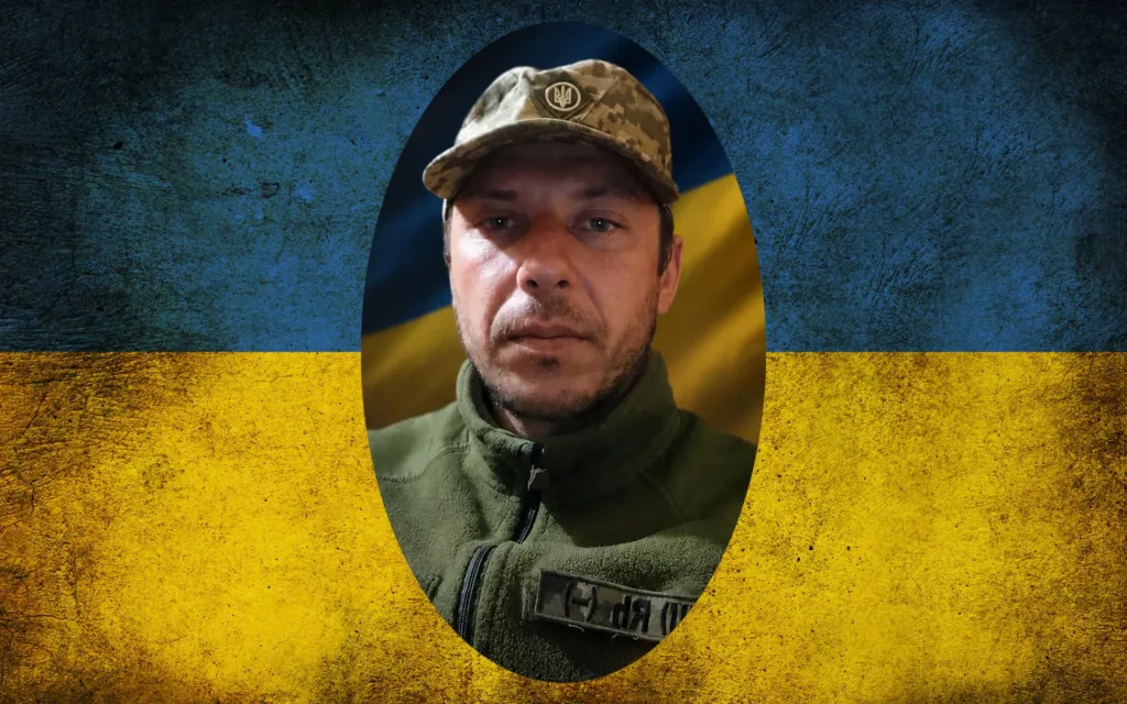 Український військовий на тлі прапора України