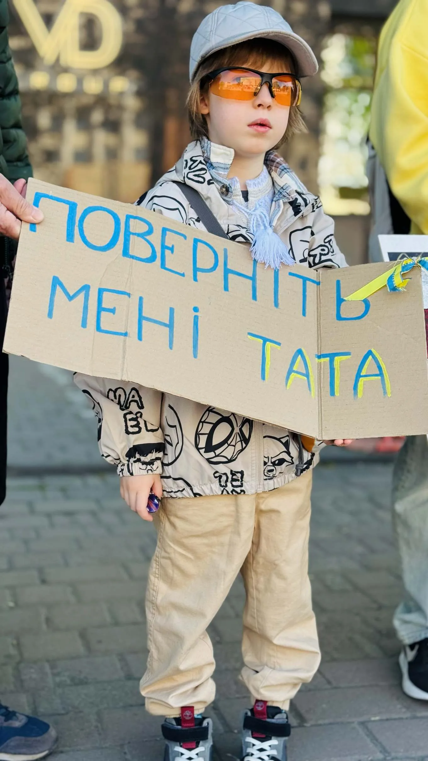 Дитина тримає плакат з написом українською