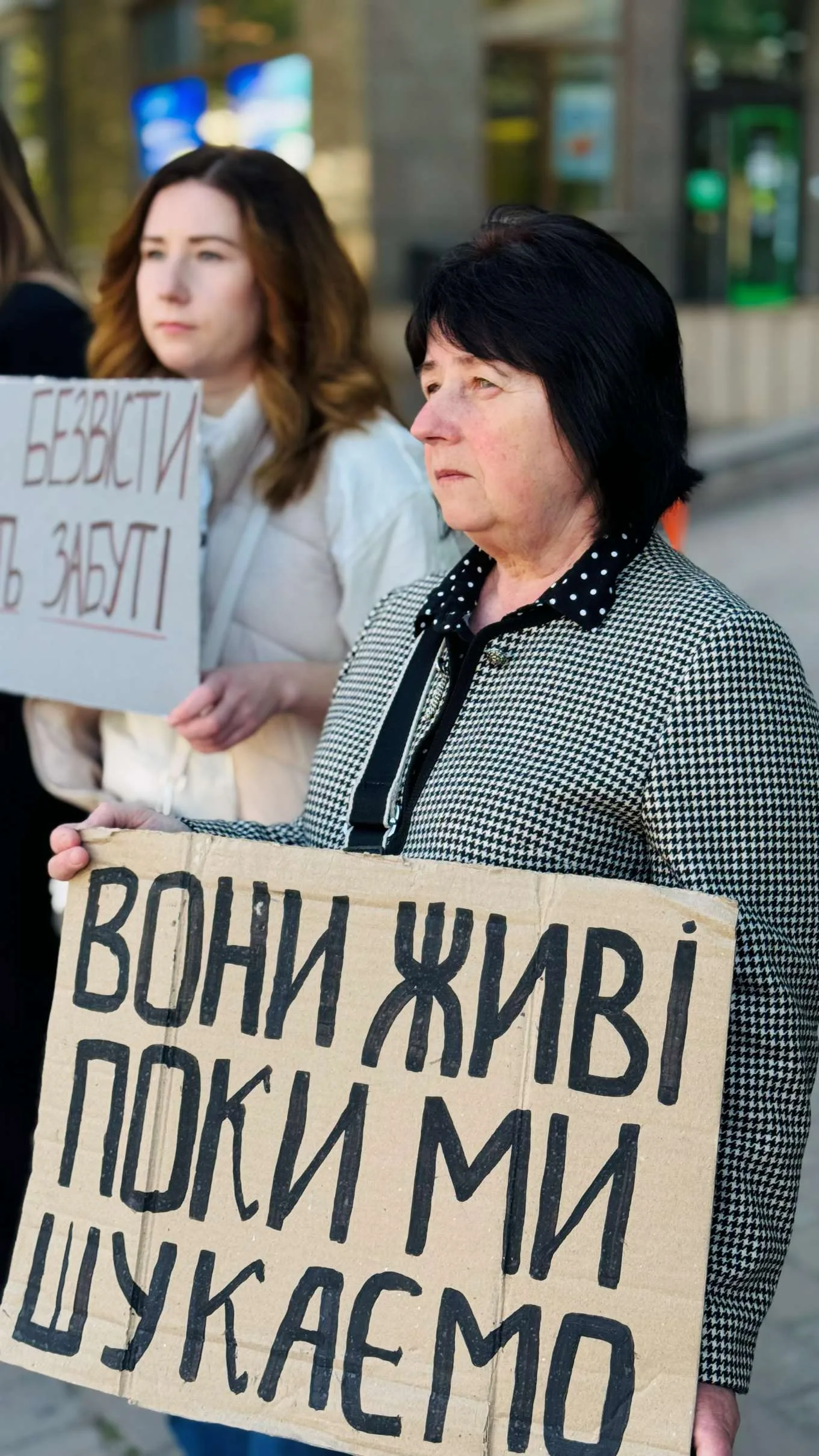 Жінки тримають плакати на мирній акції