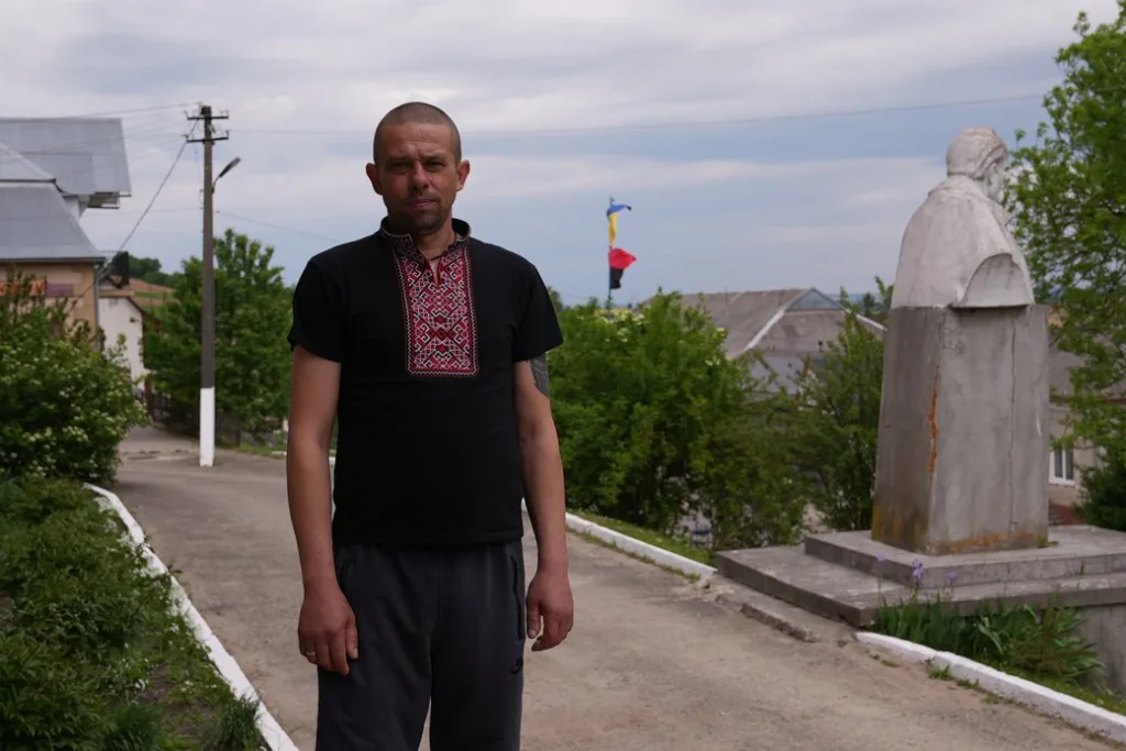 Чоловік у вишиванці стоїть біля пам'ятника