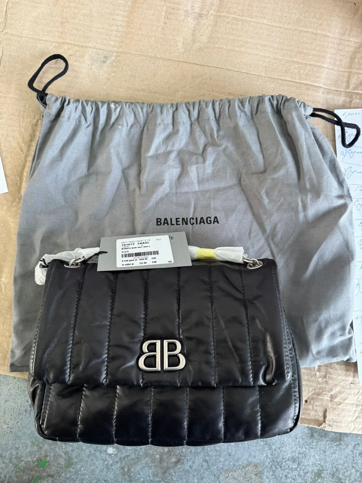 Чорна стьобана жіноча сумка Balenciaga на фоні чохла