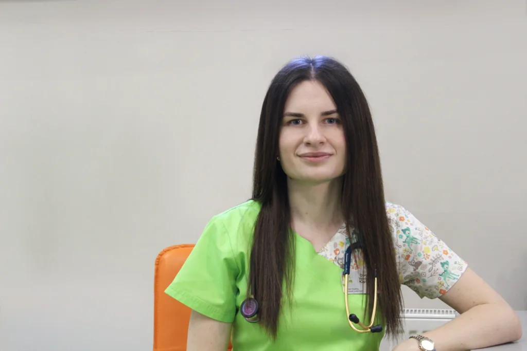 Медична працівниця у зеленому халаті з стетоскопом