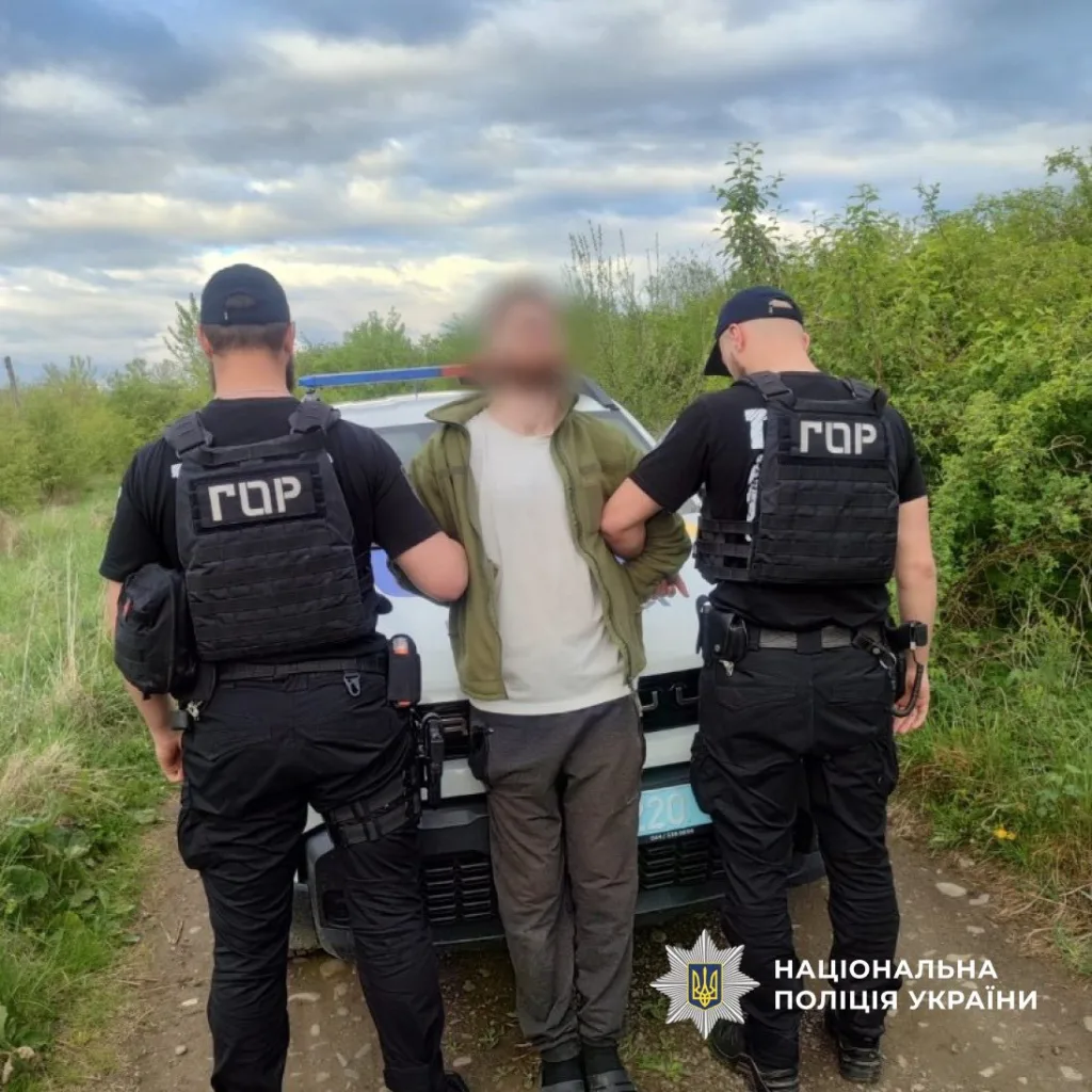 Поліція України затримує підозрюваного біля патрульного авто
