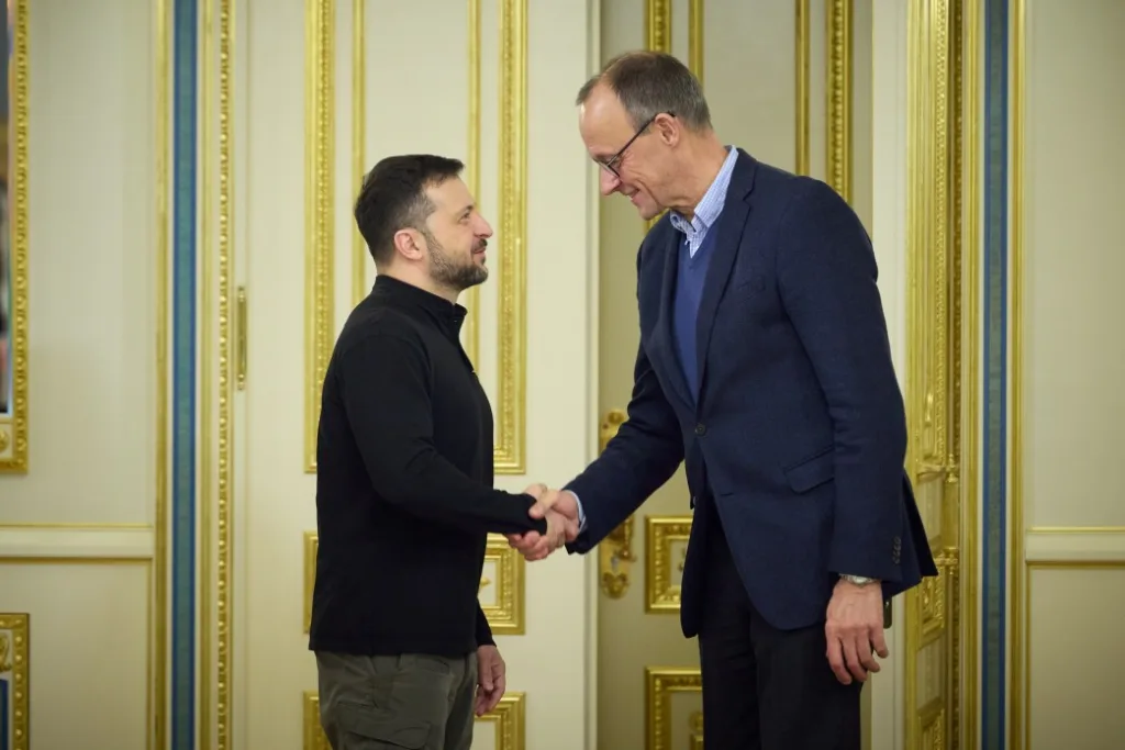 Двоє чоловіків потискають руки в урочистій залі
