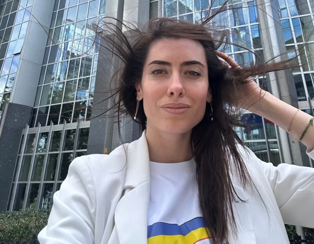 Жінка фотографується перед офісною будівлею