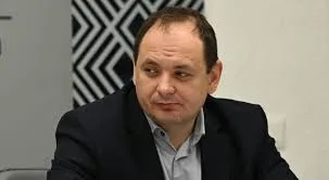 Чоловік у піджаку сидить за столом