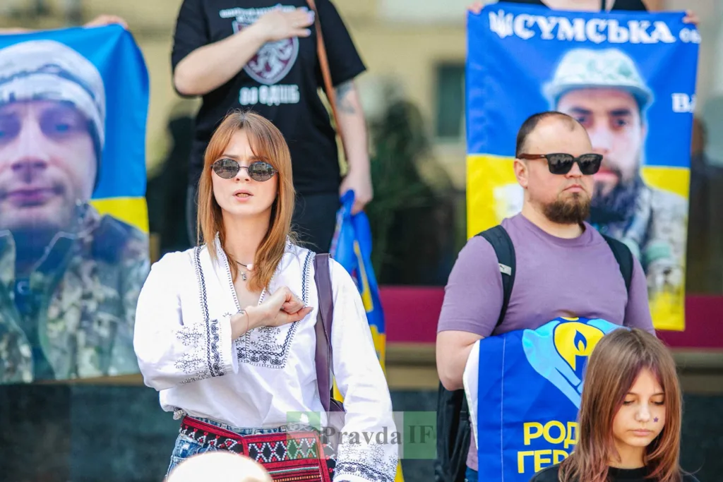 Люди на мітингу з українськими прапорами