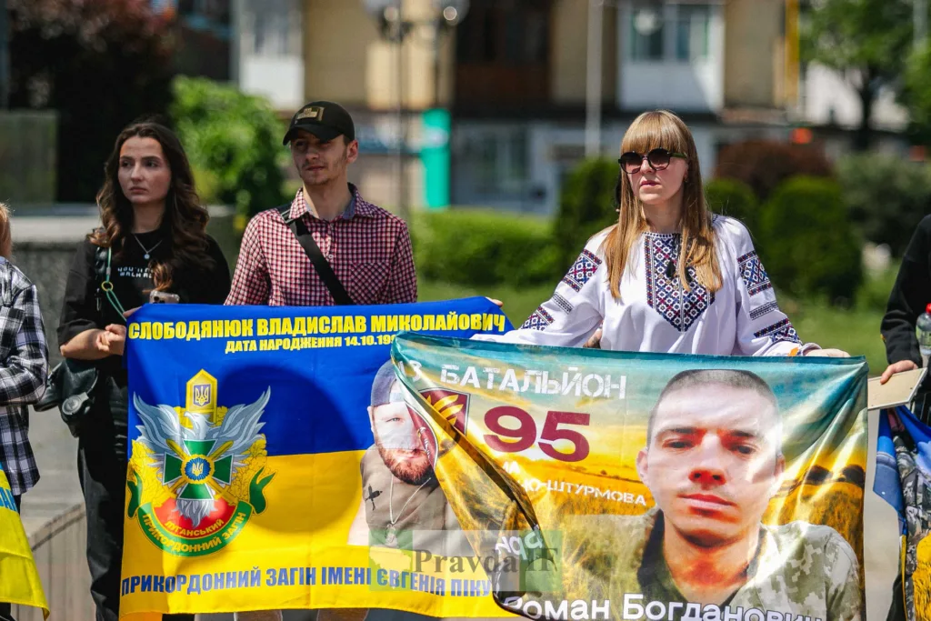 Люди тримають банери на вуличному заході в Україні