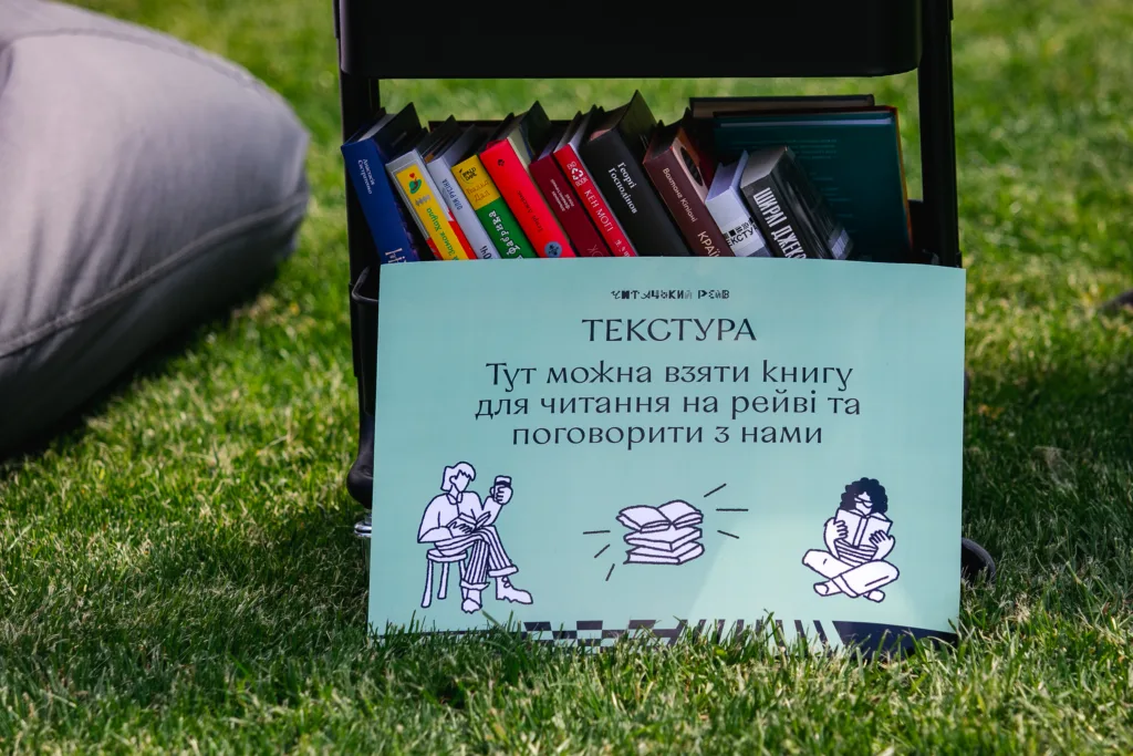 Стілець із книгами та плакат про читання на траві