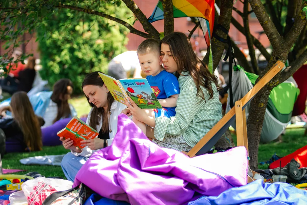 Люди читають книги на пікніку в парку