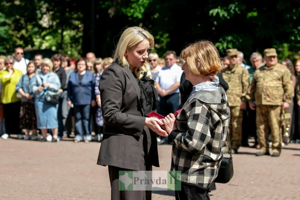 Жінка вручає нагороду на урочистій церемонії