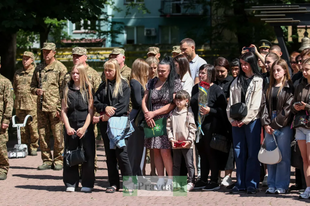 Люди вшановують військових на урочистій церемонії