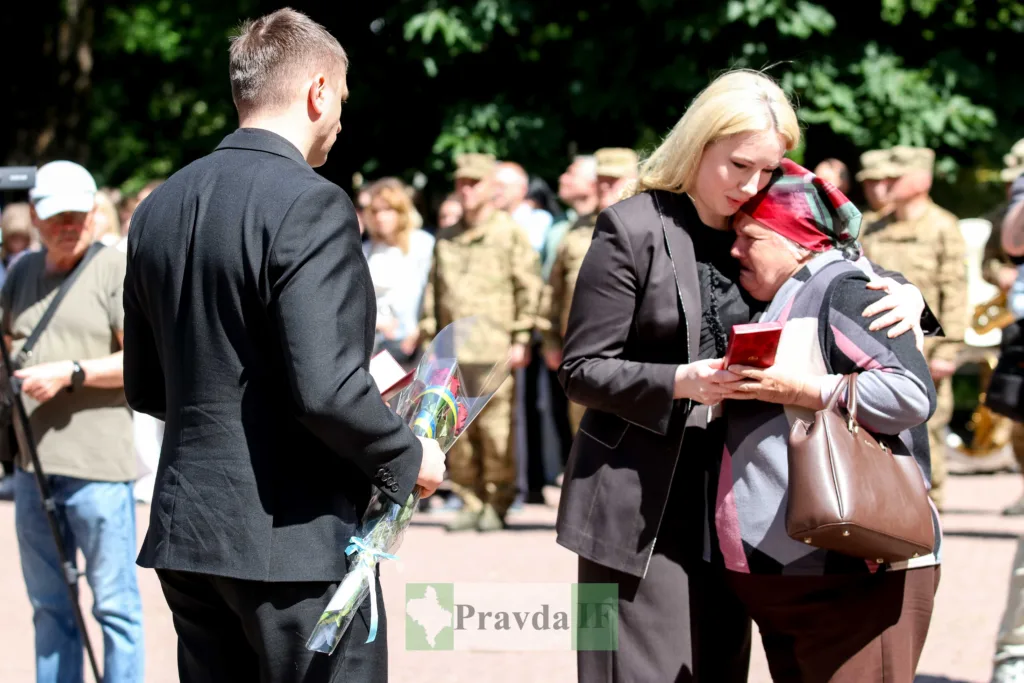 Жінки обіймаються під час військової церемонії