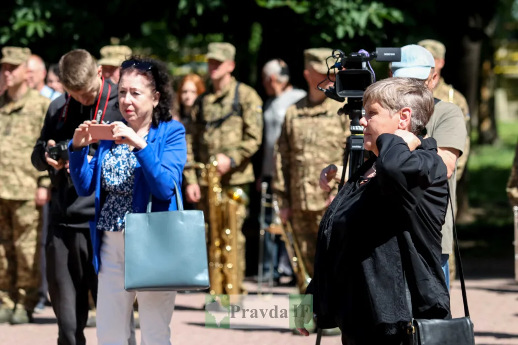 Люди фотографують військових під час заходу на вулиці
