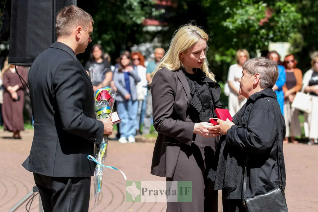 Жінка передає нагороду під час офіційної церемонії
