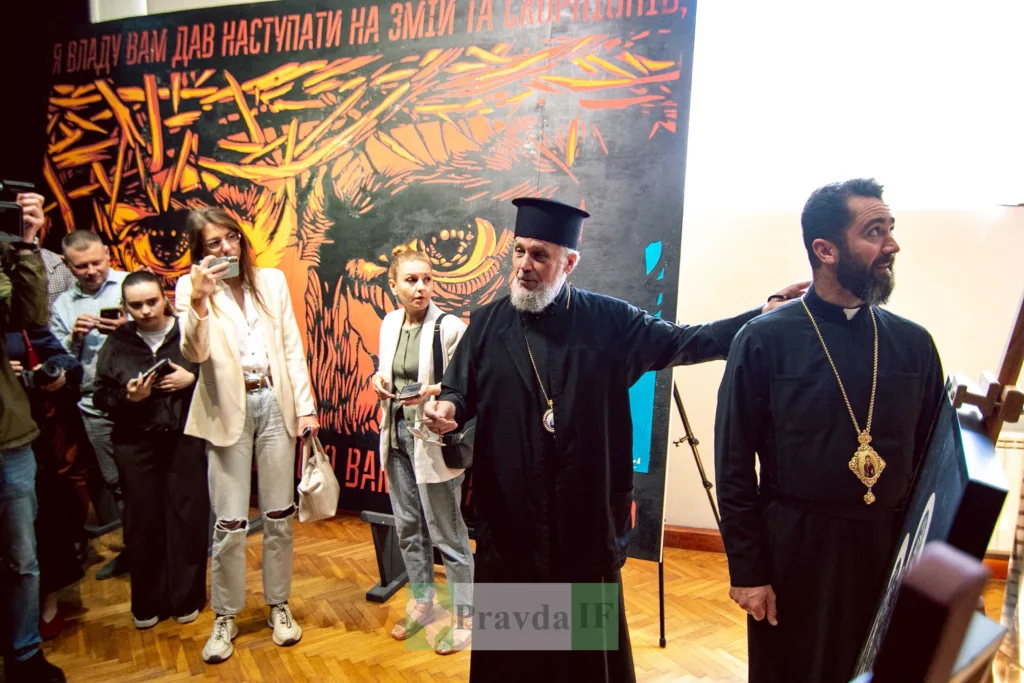 Священники на виставці перед релігійним плакатом
