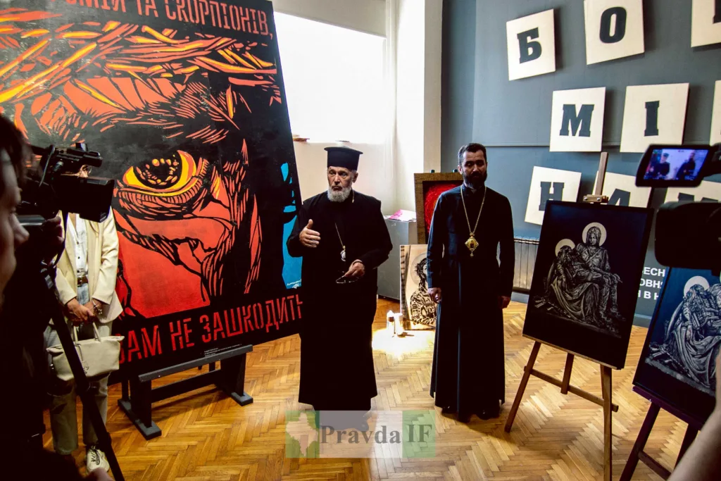 Священники біля релігійних картин на виставці мистецтва