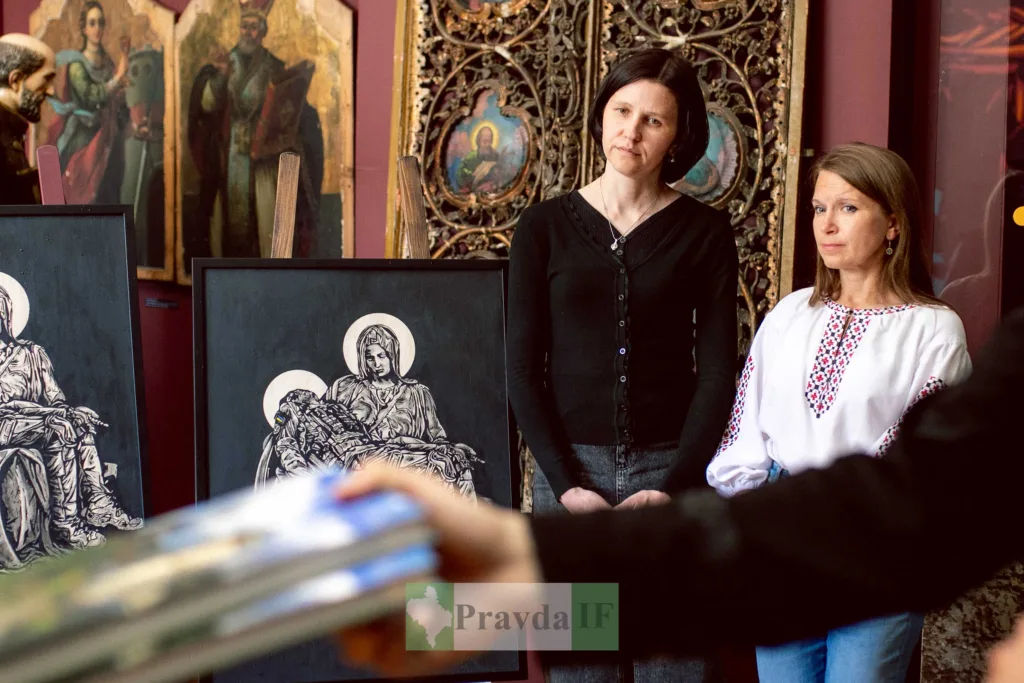 Жінки поруч із релігійними картинами в музеї