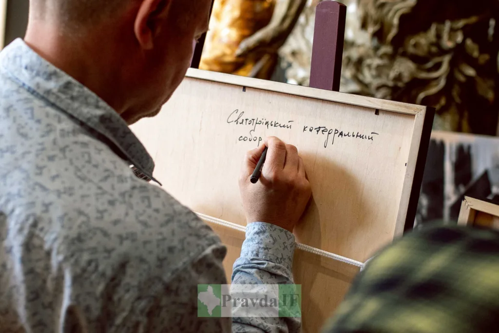 Чоловік пише текст на дошці маркером