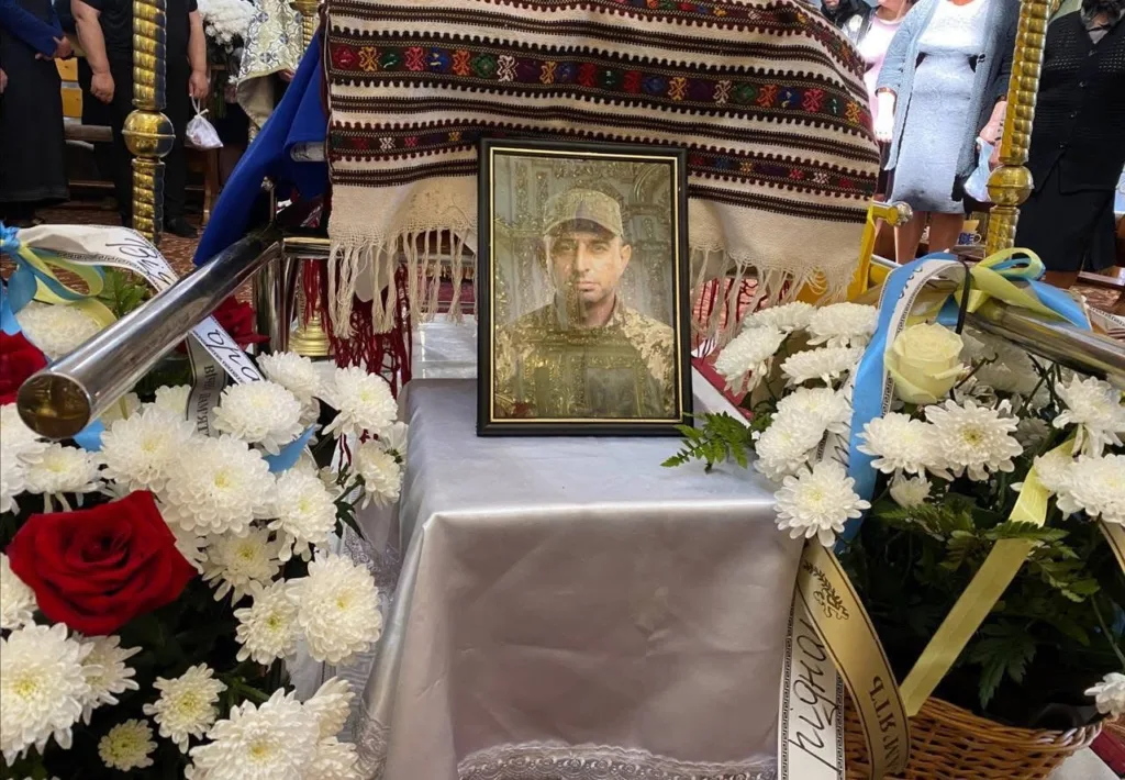 Похорон військового з квітами та портретом