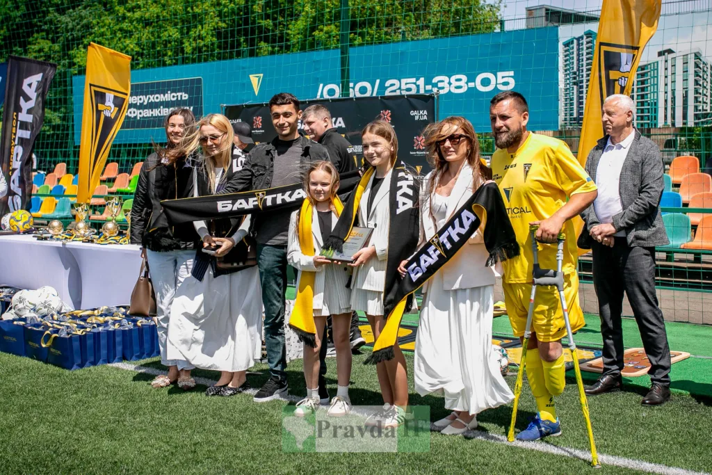 Учасники футбольного турніру на полі з нагородами