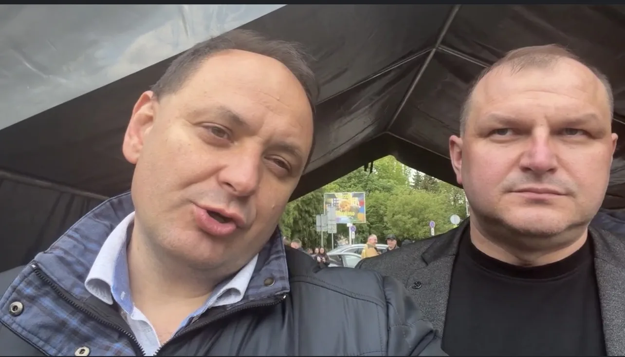 Двоє чоловіків на вулиці під навісом