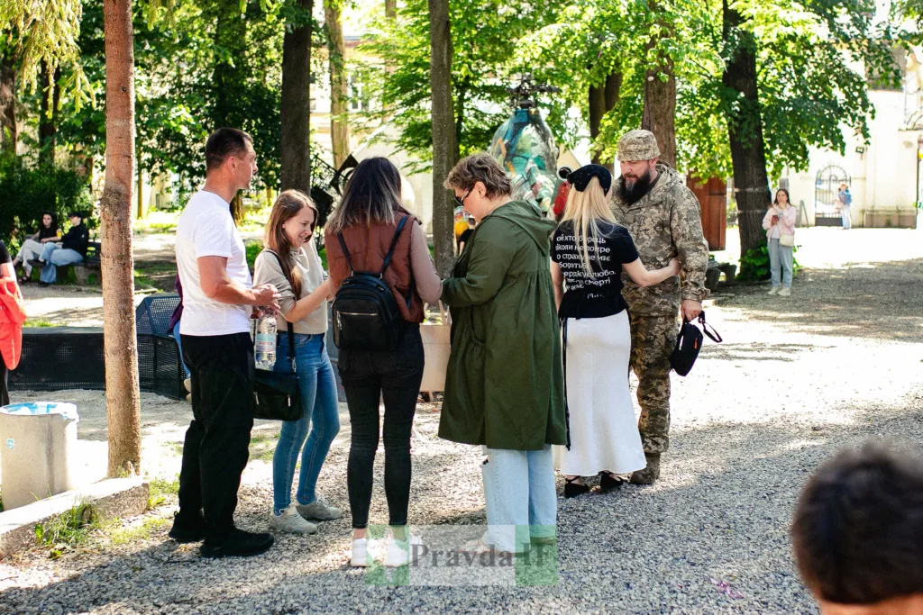 Люди спілкуються на вулиці серед дерев