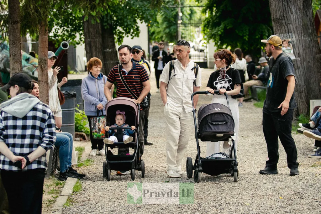 Люди гуляють у парку з дитячими візками