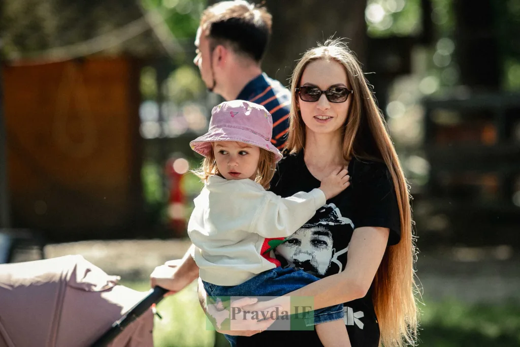 Жінка тримає дитину на вулиці