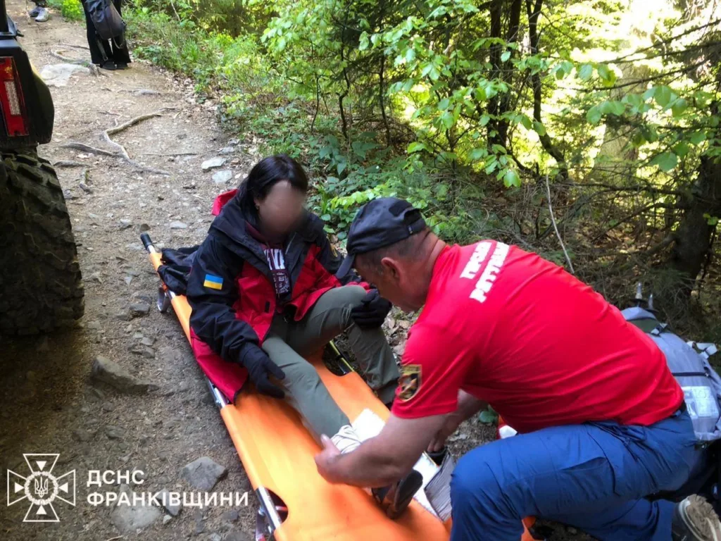 Рятувальник допомагає туристці в горах